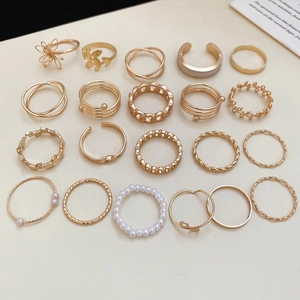 Flat lay of a 20-piece gold alloy ring set with diverse geometric and pearl designs