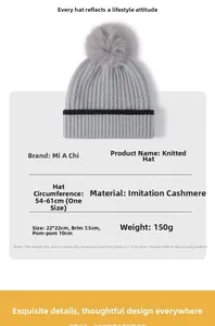 Detailed knit hat view showing grey faux cashmere fabric, black stripes, and large pompom