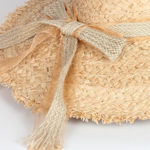 Woven raffia sun hat for women with large brim, frayed edges and bow tie decoration