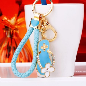 Close-up of sky blue flip-flop keychain with rhinestones and woven leather strap