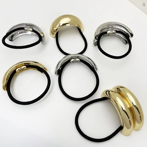 Detail view of elastic hair ties with polished gold and silver geometric metal accents
