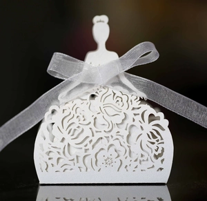 Detailed laser-cut hollow rose pattern on white wedding favor box with organza ribbon