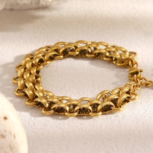 Detailed macro view of 18K gold-plated triple layered ring chain bracelet with lobster clasp