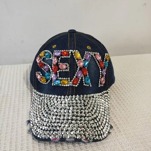 Detail of dark blue denim baseball cap with SEXY colorful rhinestone text and silver studs