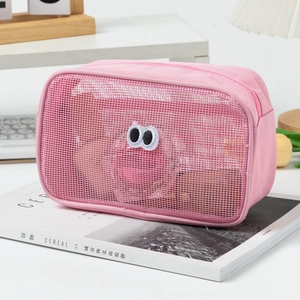 Detailed view of a pink mesh toiletry bag with 3D cartoon eyes on a lifestyle background