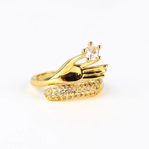 Detail of gold-plated hand-shaped ring holding a round zircon with pavé side stones