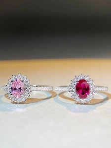 Macro detail of S925 silver rings with red and pink oval stones in halo setting