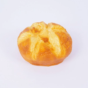 Juguete de pan croissant de espuma PU realista con textura dorada sobre fondo blanco puro