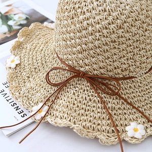 Women's summer straw beach hat with daisy patterns and a stylish wavy brim