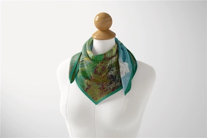 Detail of a 53cm silk scarf with green and blue oil painting print tied on a model