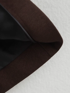 Macro shot of dark brown twill fabric with black lining and precise stitching detail