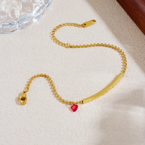 Gold stainless steel chain bracelet with red heart pendant shown in a stylish S-shape layout
