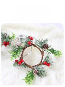 Detail of Christmas candle ring with pine needles, red berries and small cones