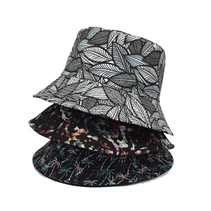 Three stylish printed bucket hats for women featuring tropical leaves and abstract patterns
