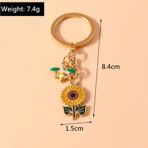 Detail showing bee and sunflower charms on a gold keychain with 8.4cm total length