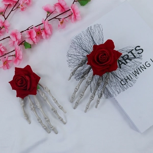 Gothic Halloween hair clip featuring a skeleton hand holding a red rose with black mesh