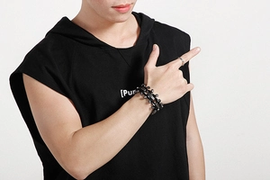 Industrial style black metal chain bracelet shown on male model wrist with focus on texture