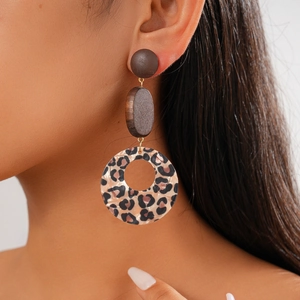 Close-up of geometric acrylic leopard print earrings with wooden beads and silver pins