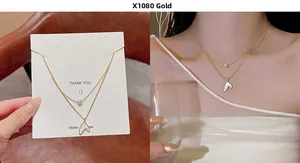 Detail of a double-layer gold titanium necklace with a white pearl and fish tail pendant