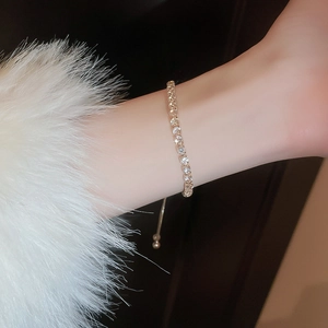 Close-up of luxury gold crystal bracelet with zircon inlay on model wrist with fur cuff