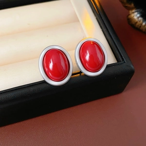 Macro shot of oval red gemstone earrings with polished silver-tone metallic borders