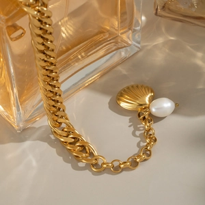 Gros plan détaillé du bracelet en chaîne plaqué or 18 carats avec coquillage et perle