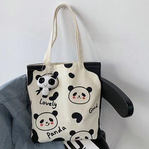 Detail der Panda-Stofftasche mit süßem Cartoon-Druck und Panda-Plüsch-Schlüsselanhänger