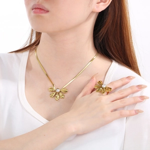 Detail of 18K gold petal necklace and ring set with pearls on elegant snake chain