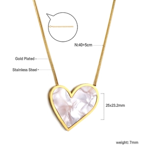 Detail of gold plated stainless steel heart necklace with white mother of pearl inlay