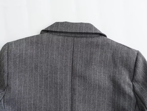 Detail of pinstripe wool blend blazer showing collar structure and back shoulder seams