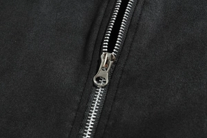 Macro shot of high-quality silver metal zipper on a black textured jacket fabric