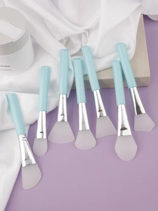 Macro detail of seven silicone mask brushes with blue handles and flexible white tips