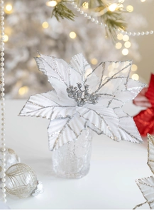 Macro detail of white velvet Christmas poinsettia with silver glitter and mesh texture