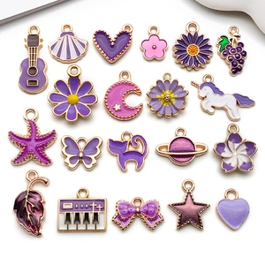 Flat lay of 19 purple enamel charms in various shapes for DIY jewelry making