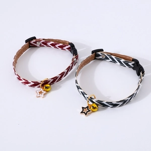 Close-up of adjustable pet collars with red and black wave patterns and gold bell charms