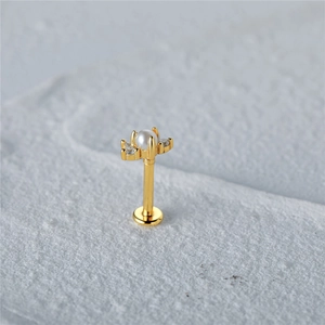 Detail of gold butterfly ear stud with a white pearl and sparkling zircon stones