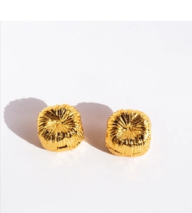 Macro shot of gold earrings featuring distinctive sunburst texture and radial pleat design