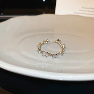 Detailed view of silver butterfly ring with cubic zirconia on white ceramic tray