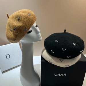 Close-up of wool berets with sparkling star rhinestones in camel, black, and off-white