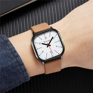 Close-up of British style square quartz watch with brown leather strap on wrist