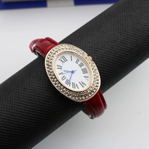 Close-up of oval rose gold watch case with double-row crystals and red leather strap