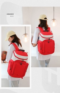 Detail view of red and white basketball backpack with sturdy top handle and side pockets