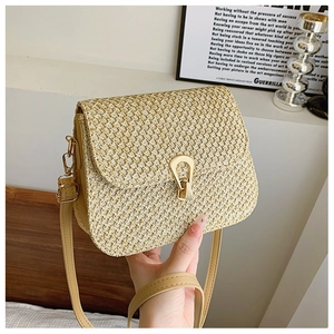 Detail of cross-weave texture on beige straw crossbody bag with gold horsebit buckle
