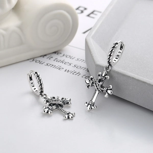 Detailed macro view of vintage 925 silver hoop earrings featuring engraved cross charms