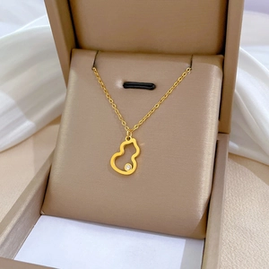 Gold titanium steel gourd necklace with diamond in a jewelry gift box on white cloth