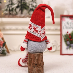 Detail of Christmas gnomes with knitted elk pattern hats sitting on wooden stumps