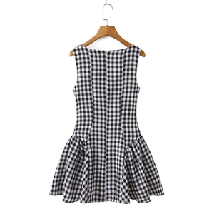 Detail of black and white plaid sleeveless dress featuring a ruched skirt and flared cut