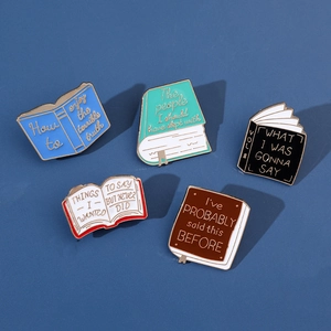 Detailed flat lay of five assorted colorful book enamel pins with creative quotes