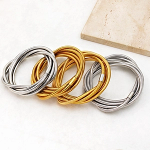 Set of four stacked spring snake bone bracelets in gold and silver stainless steel