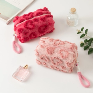 Detail view of heart-patterned plush makeup bags with soft texture and sturdy rope handles